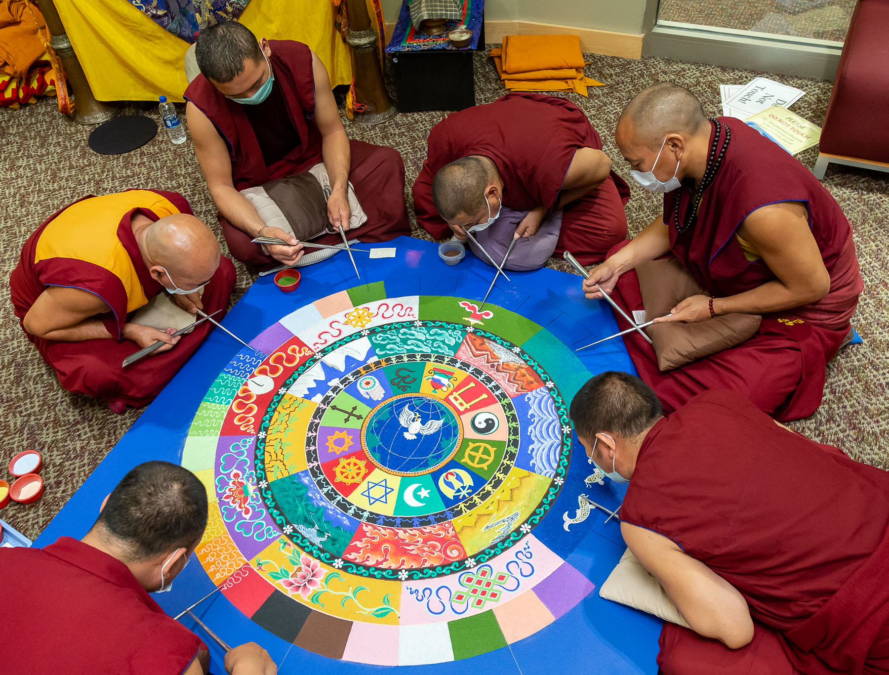 After five days of slow, meticulous progress, several monks work together to finish the mandala on Friday. (DePaul University/Jeff Carrion)